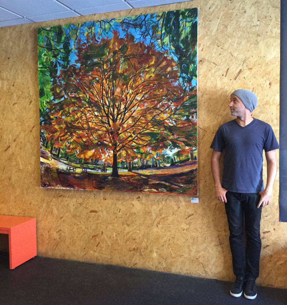 Noel Hefele standing next to a painting