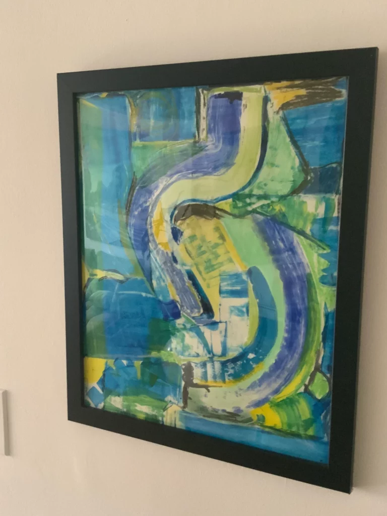 Close-up of blue and green abstract painting hanging on wall