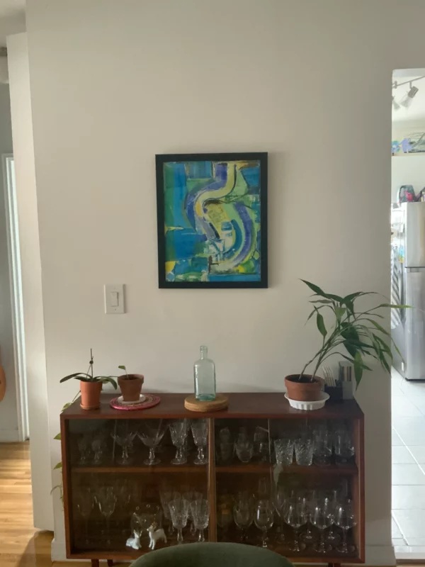 Front view of blue and green abstract painting hanging on wall