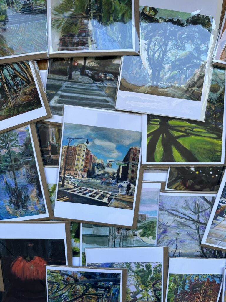 Assortment of colorful greeting cards featuring diverse artworks from cityscapes to nature scenes.