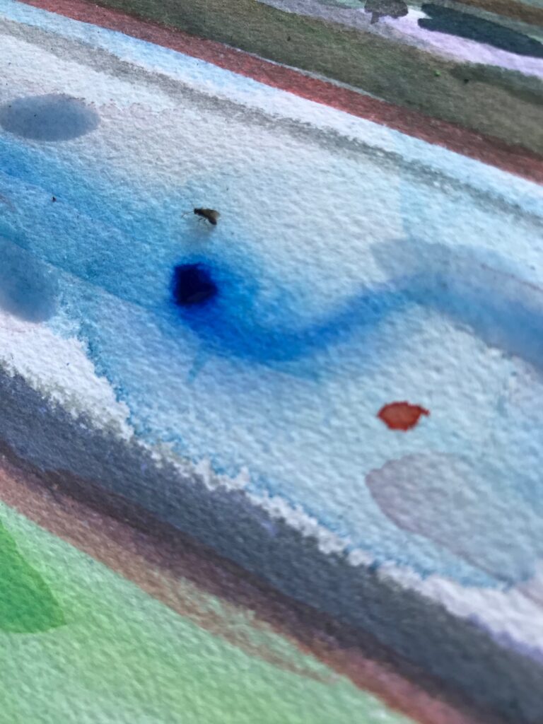 Close-up of a watercolor painting capturing the texture and vivid blue of Siren Slope's landscape with an insect walking over the paper..