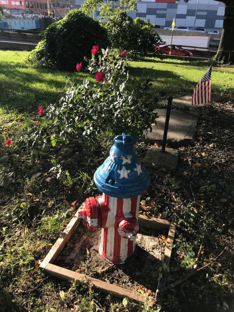 A vibrantly painted fire hydrant adorned with the American flag colors at Siren Slope, symbolizing local pride and remembrance.