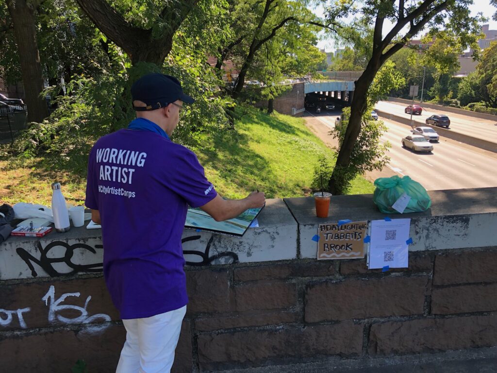 An artist in a purple shirt is captured from behind, painting the urban scene of W 233rd Street.