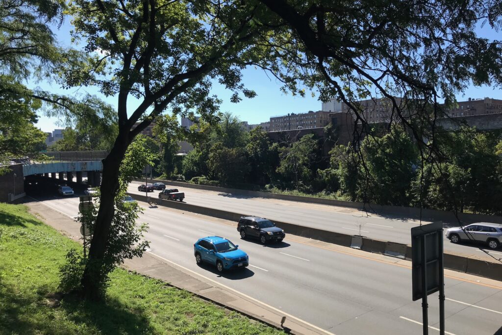 A tree-lined view over the Major Deegan Expressway, capturing the essence of the urban landscape that inspires the "Daylighting Tibbetts Brook en Plein Air" series.